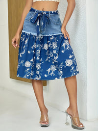 Blue floral skirt with denim waistband worn by a person on a neutral background