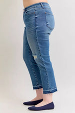 Blue jeans worn by a person on a plain background