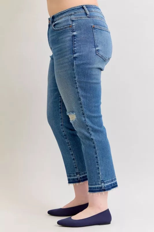Blue jeans worn by a person on a plain background