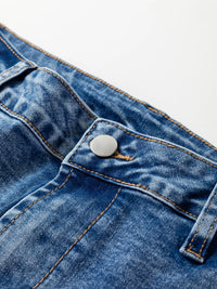 Close-up of a blue denim button on a white background