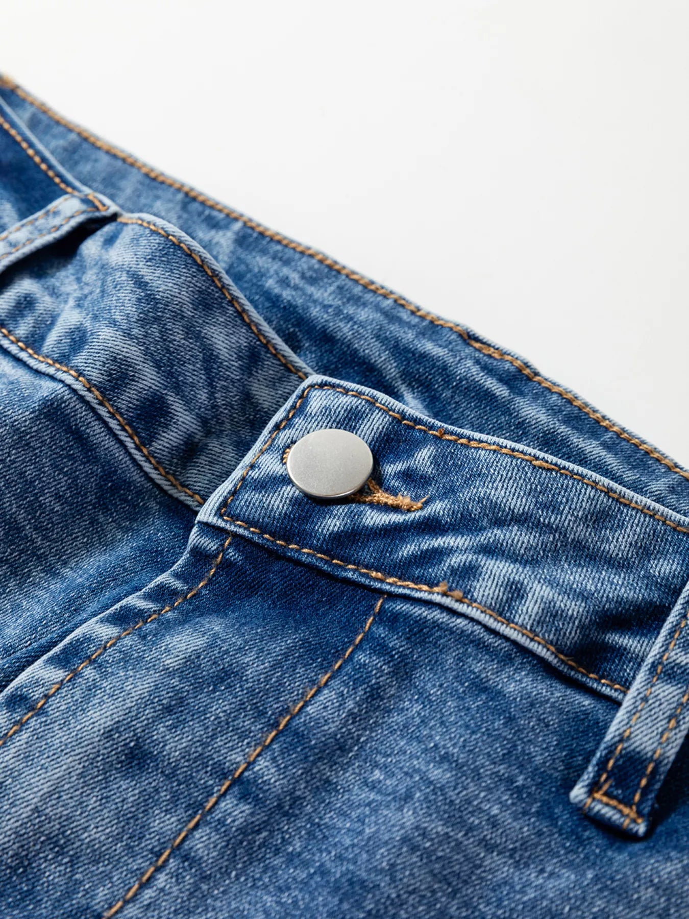 Close-up of a blue denim button on a white background