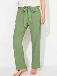 Green wide-leg pants with a tie waist worn by a person on a white background