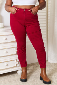 Person wearing red pants and brown boots in a room with a white dresser.