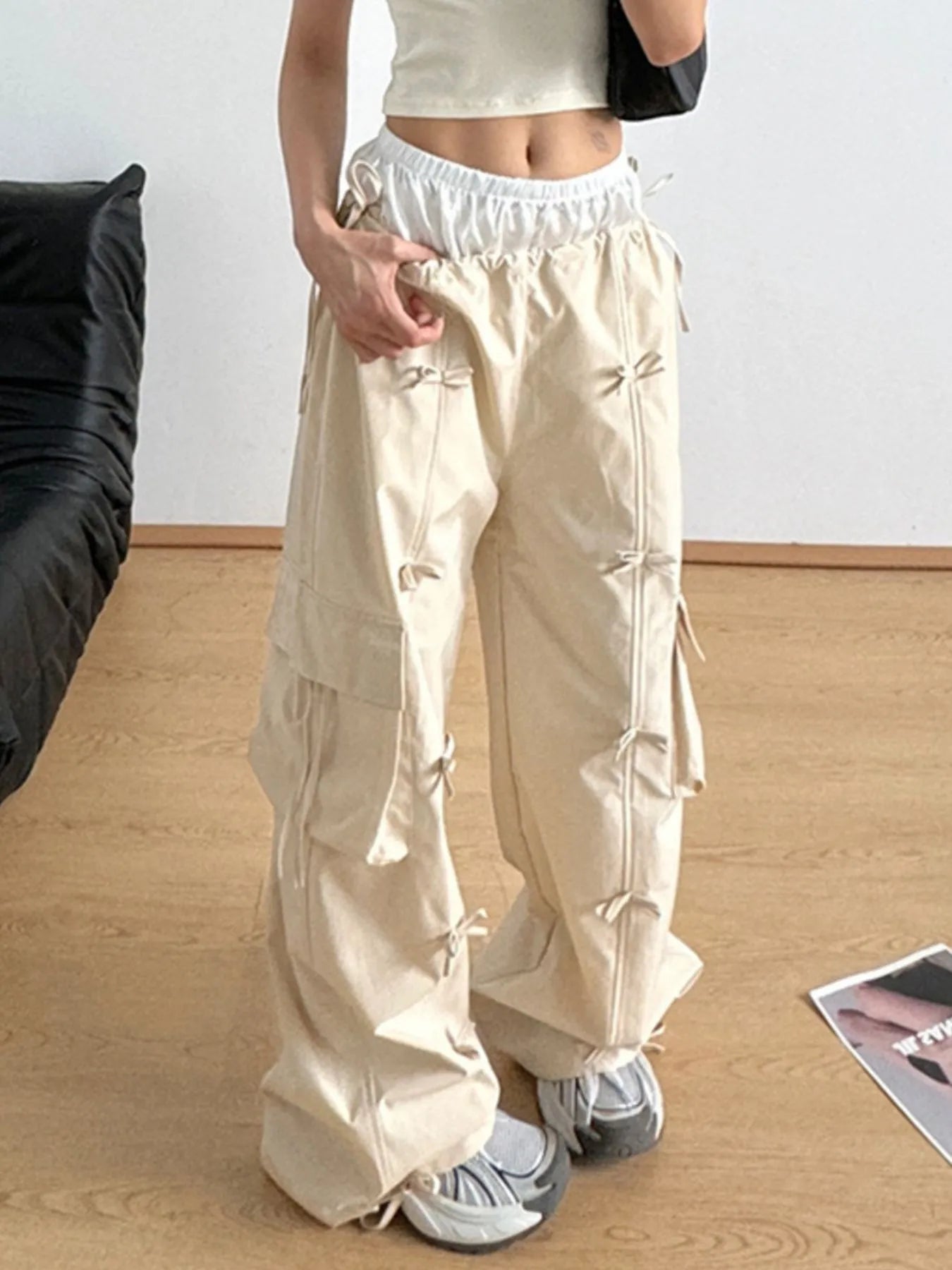 Person wearing beige cargo pants in a minimal indoor setting