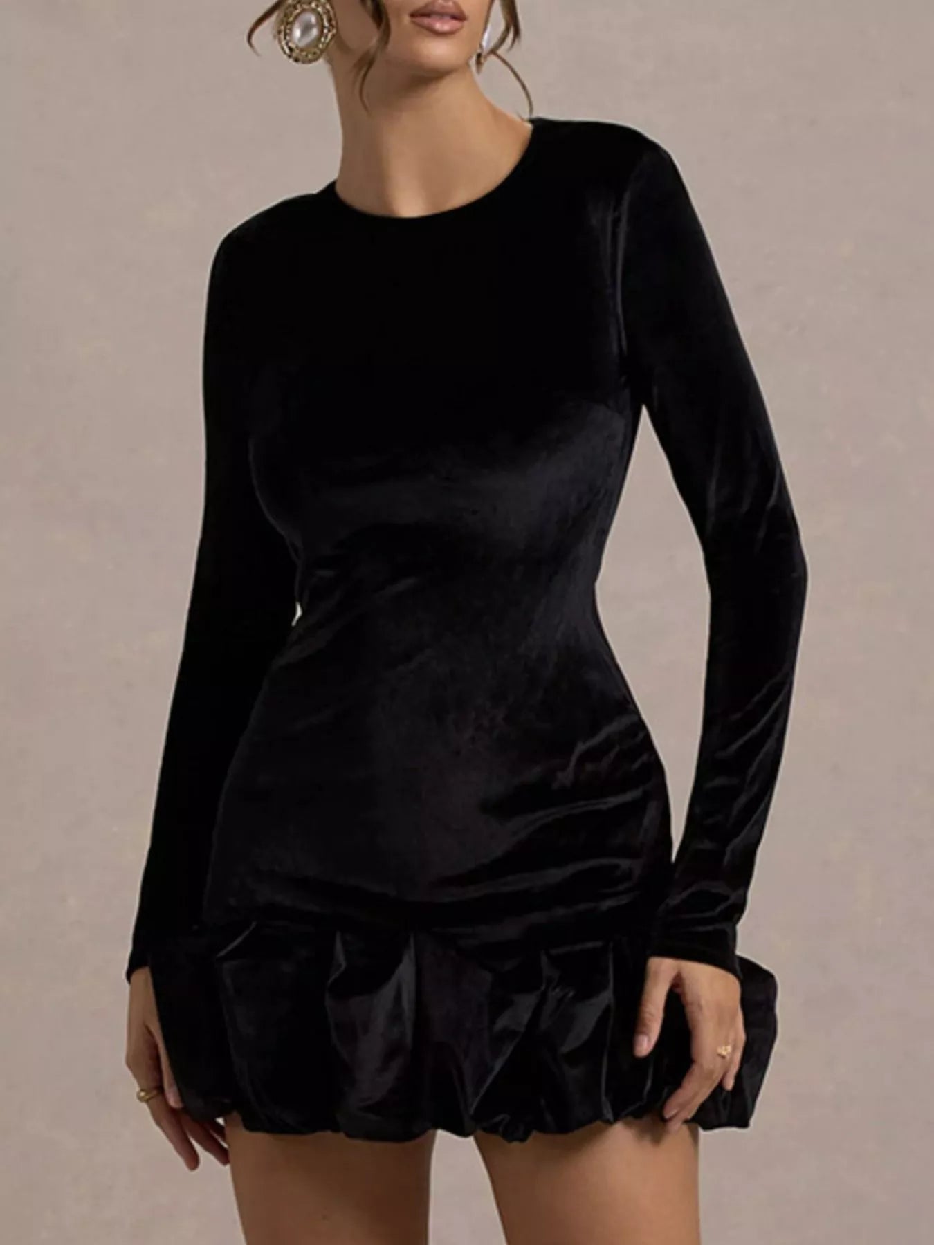 Black velvet dress with long sleeves on a neutral background