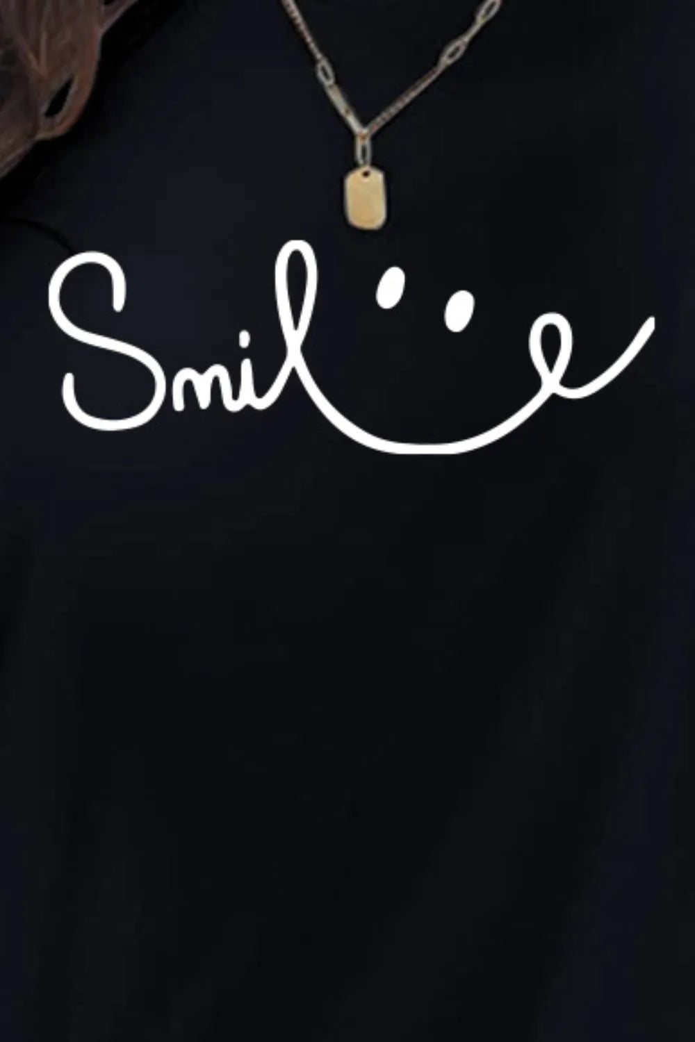 Black shirt with 'Smile' text and necklace on a dark background