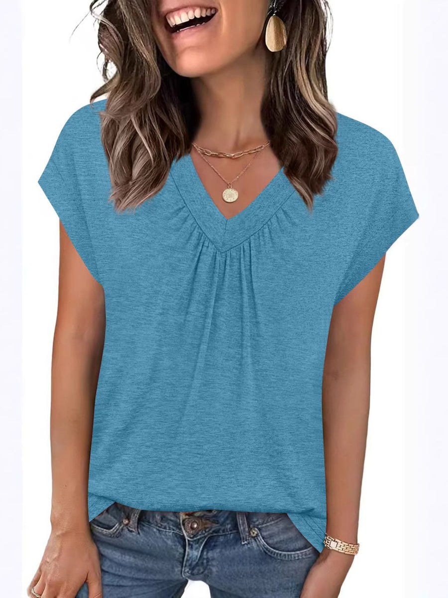 Woman wearing a blue cap sleeve top on a white background