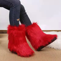 Red furry boots worn with blue jeans on a neutral background