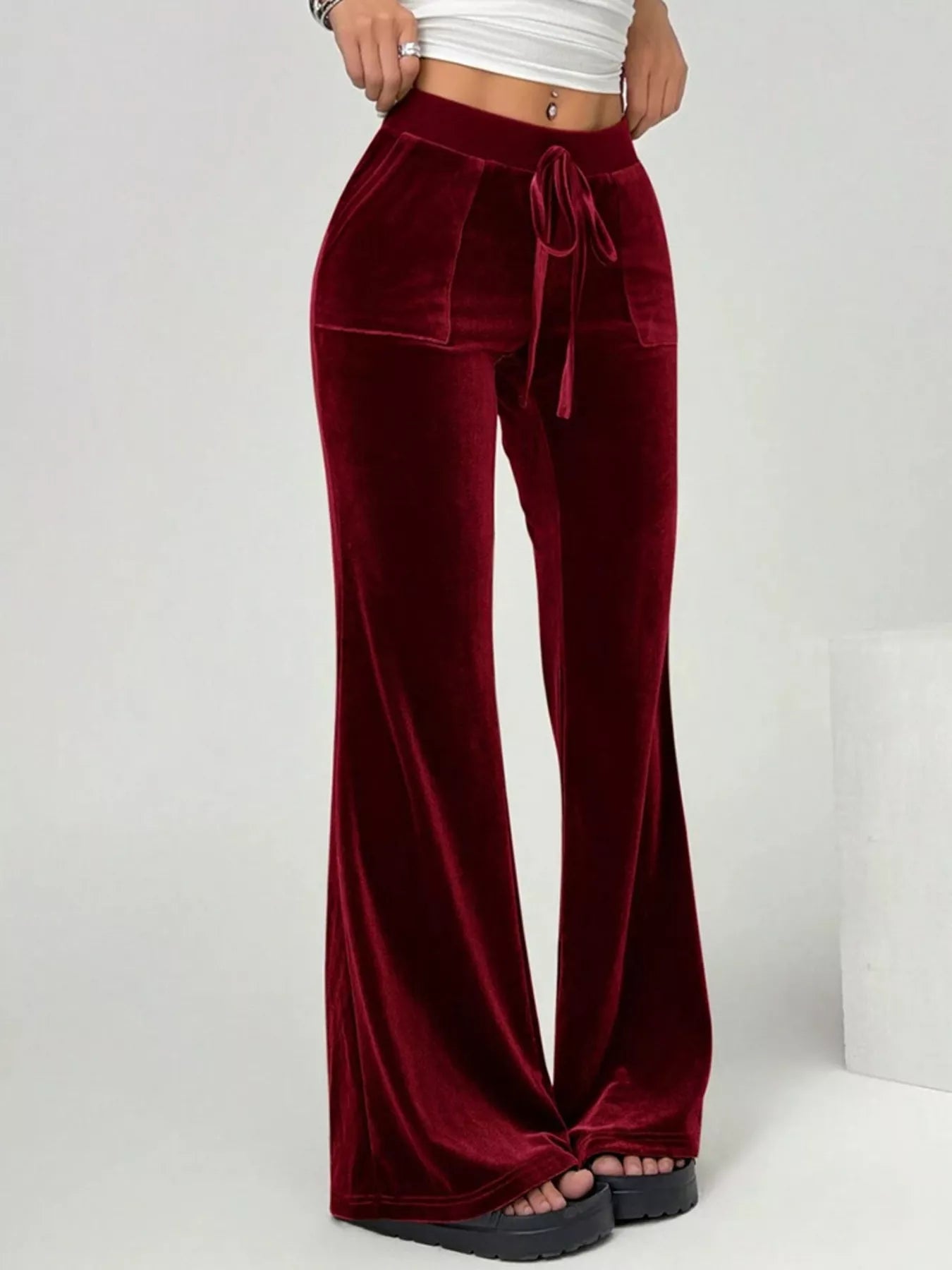 Wine red velvet pants with a drawstring waist on a white background