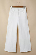 White wide-leg jeans hanging on a wooden hanger against a beige background