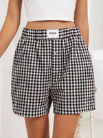 Person wearing black and white checkered shorts with a visible brand label on a white background