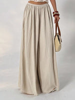 Beige wide-leg pants worn by a person on a white background