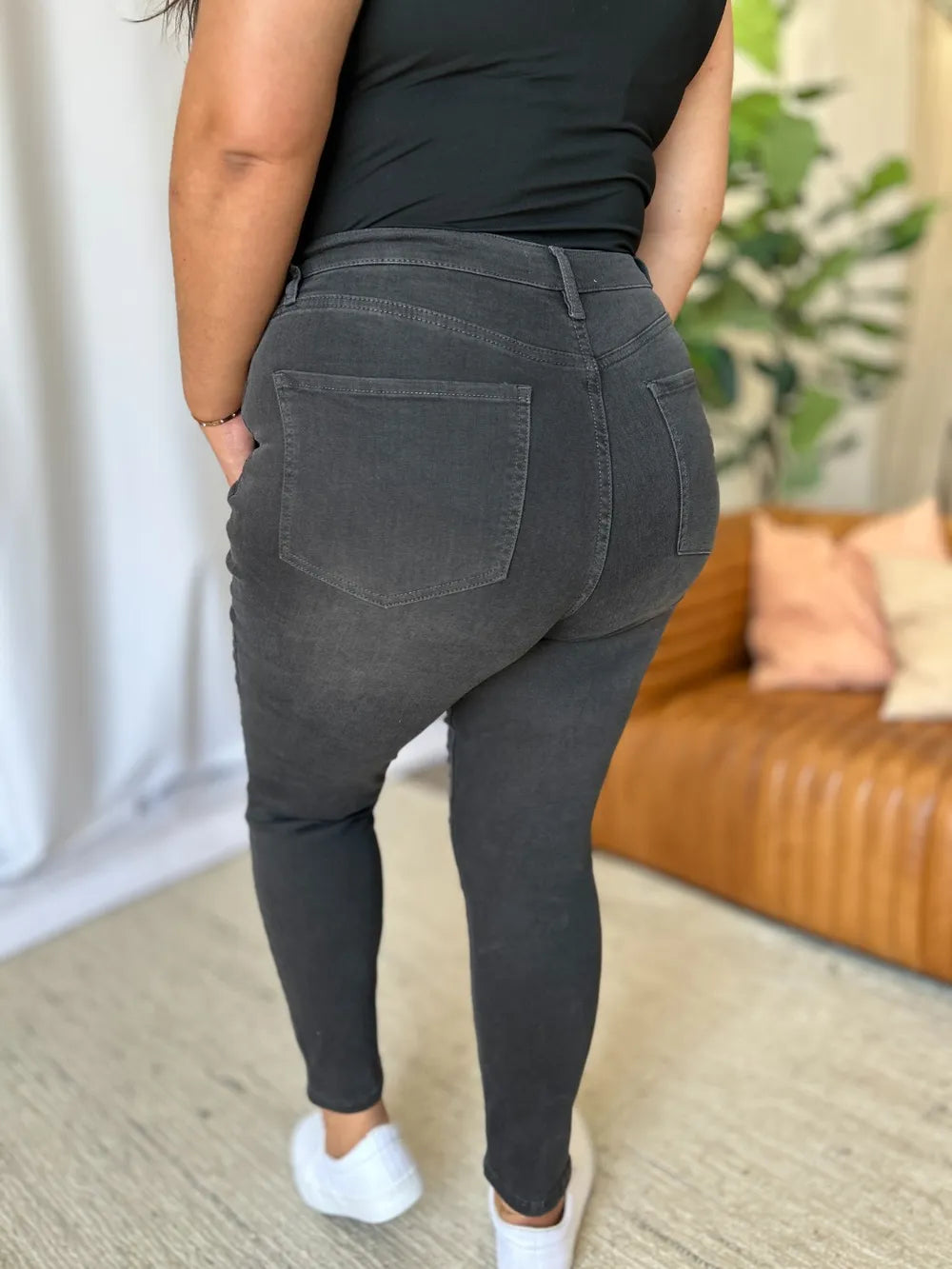 Person wearing dark gray jogger pants with a blurred indoor background