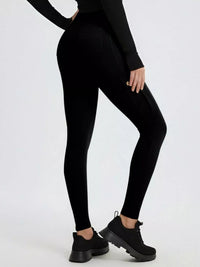 Person wearing black leggings and black shoes on a white background