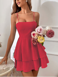 Woman wearing a red dress holding a bouquet of flowers indoors.
