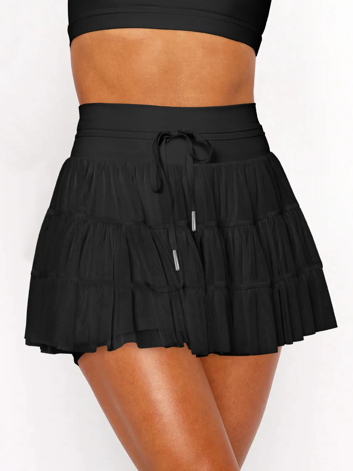 Black tiered skirt worn by a person on a white background