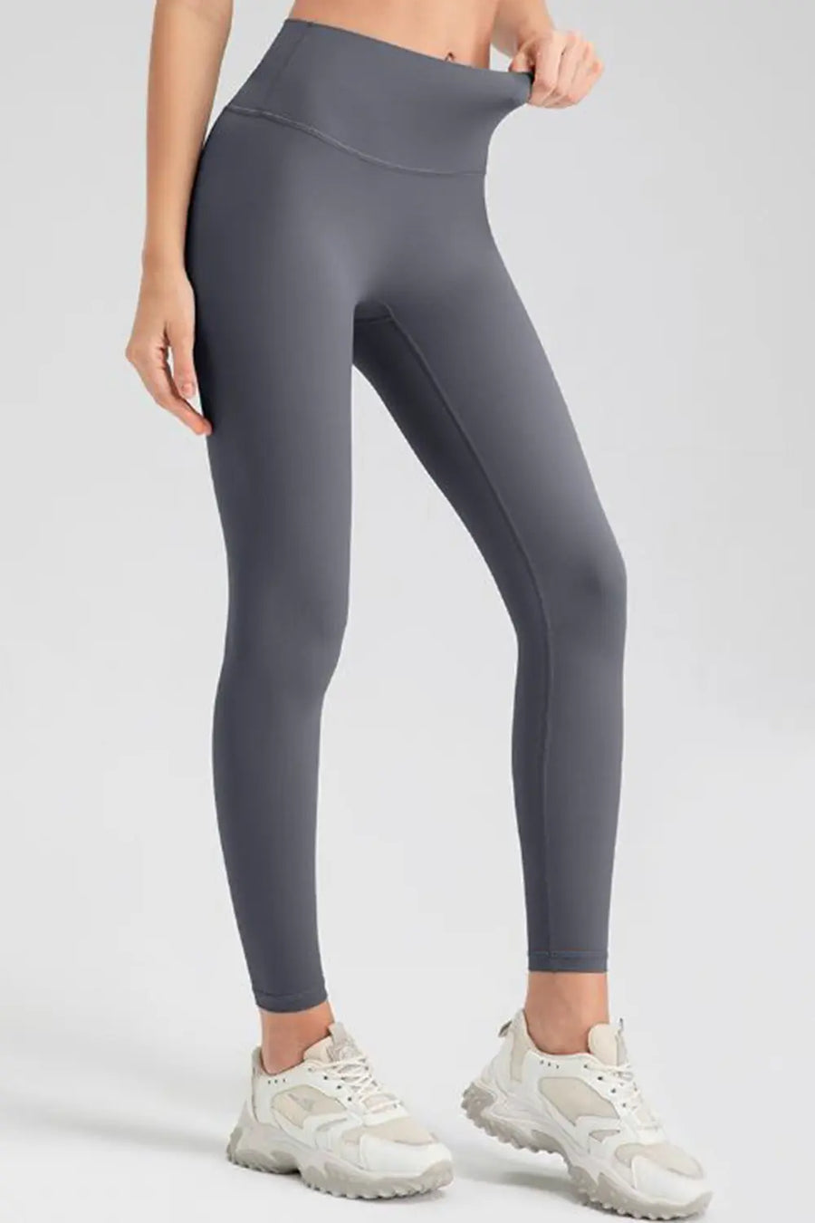 Person wearing gray leggings on a white background