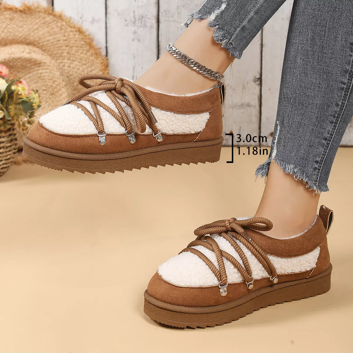 Brown and white shoes worn with denim jeans on a neutral background