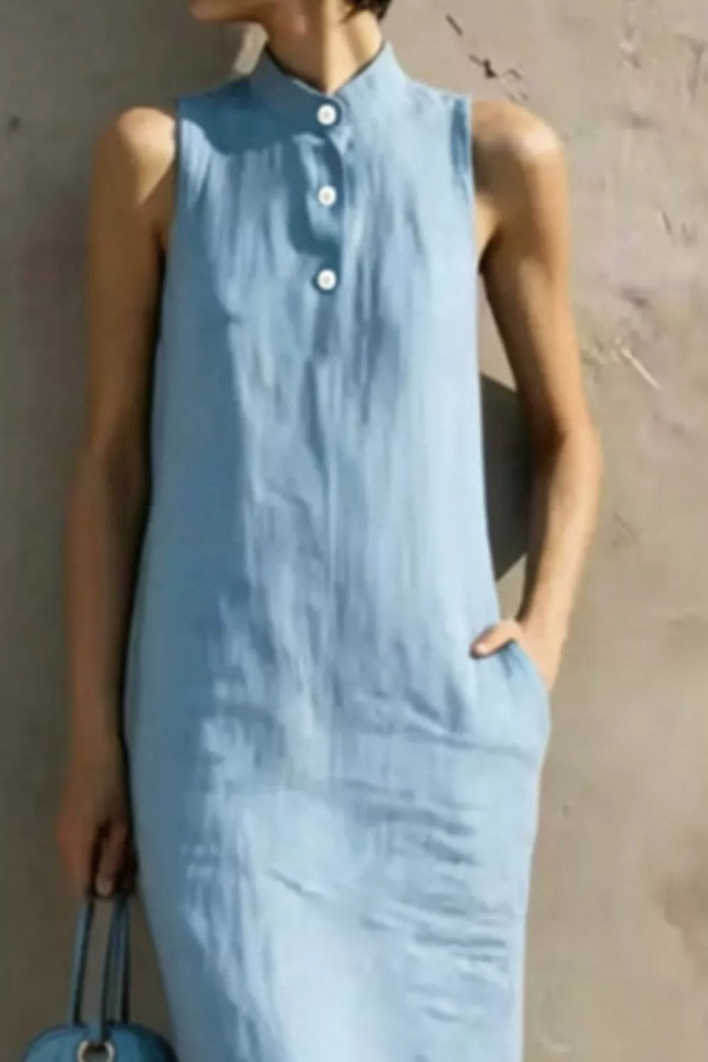 Light blue sleeveless dress worn by a person against a neutral background
