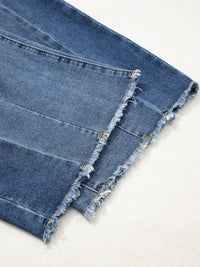 Close-up of blue denim fabric with frayed edges on a light background