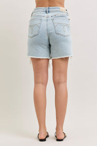 Light blue denim shorts worn by a person on a plain background