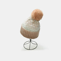 Knitted beanie with a pom-pom on a white background