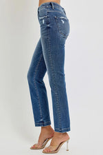 Blue jeans worn by a person on a plain background