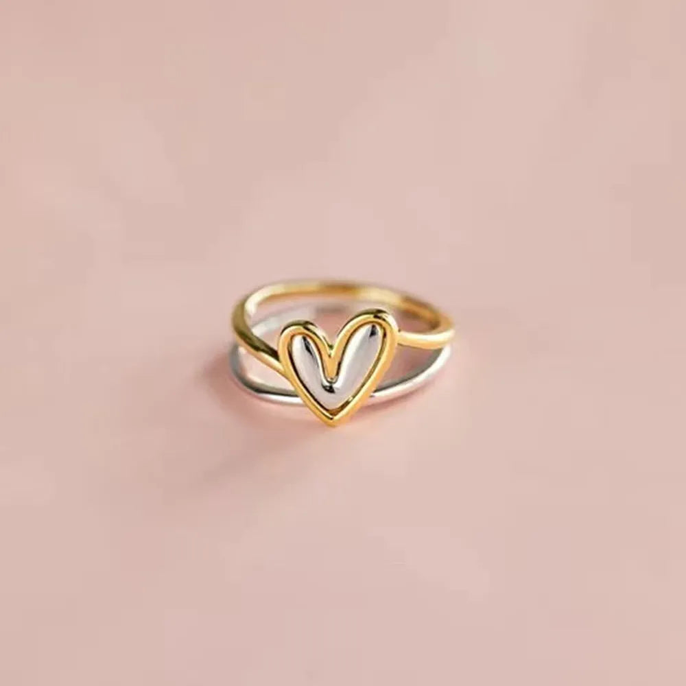 Two-tone heart-shaped ring on a beige background