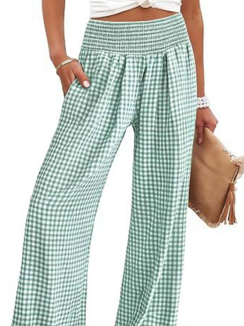 Green and white checkered pants worn by a person on a white background