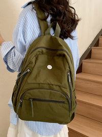 Person wearing a green backpack indoors