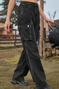 Person wearing black cargo pants holding a black bag outdoors.