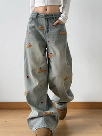 Light blue jeans with patches worn by a person on a plain background