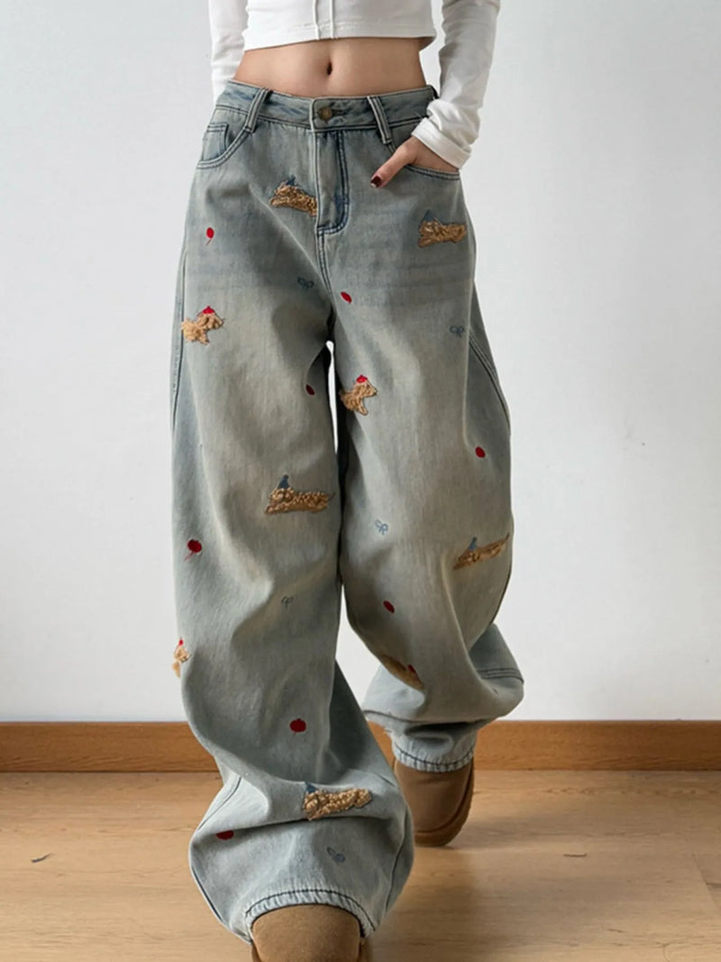 Light blue jeans with patches worn by a person on a plain background