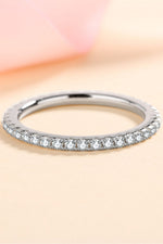 Silver ring with small diamonds on a soft pink background