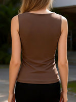 Brown sleeveless top worn by a person with a blurred background