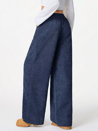 Person wearing blue wide-leg jeans on a white background