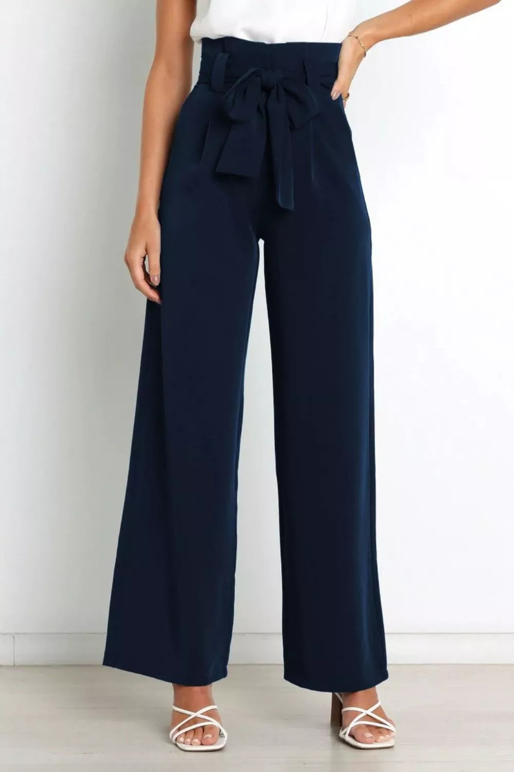 Navy wide-leg pants with a tie waist worn by a person on a white background