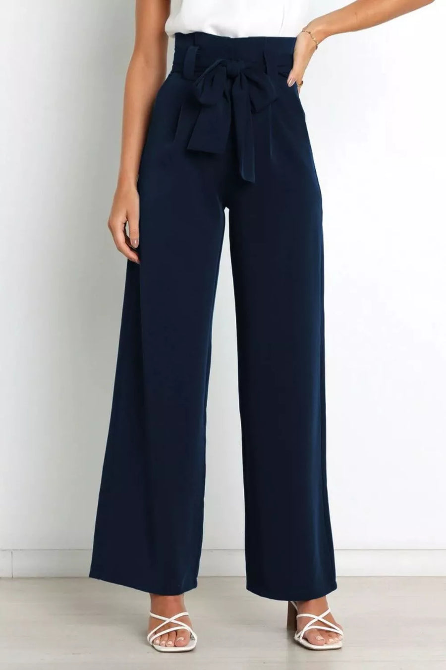 Navy wide-leg pants with a tie waist worn by a person on a white background