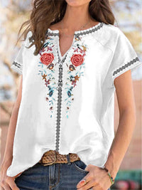 White blouse with floral embroidery and short sleeves worn by a person.