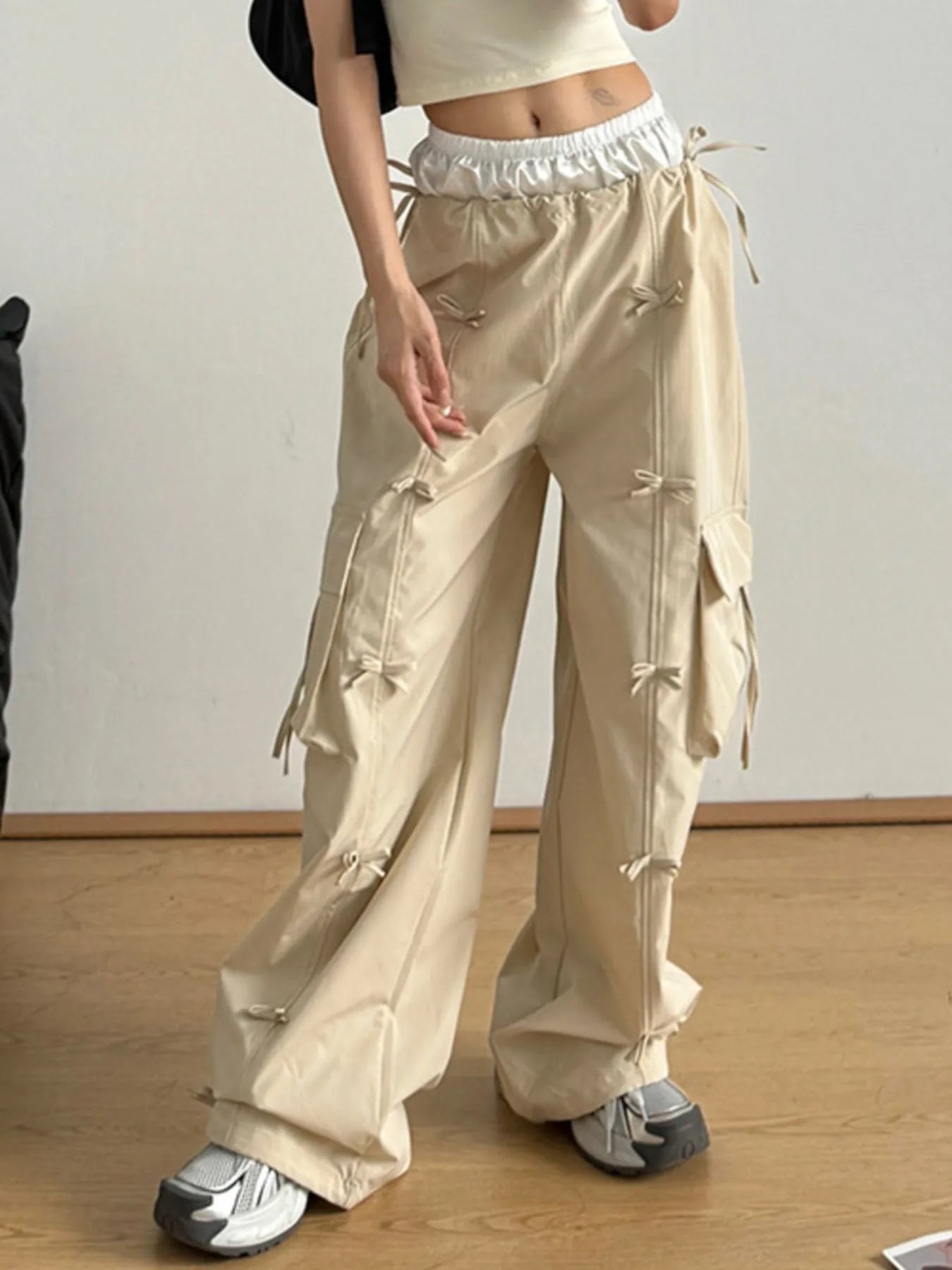 Person wearing beige cargo pants on a plain background