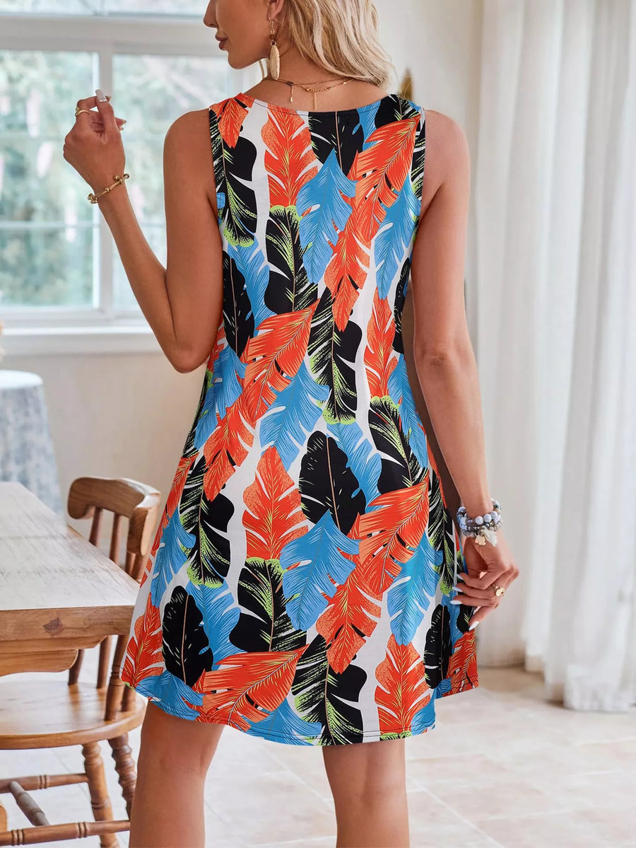 Woman wearing a colorful leaf-patterned dress indoors.