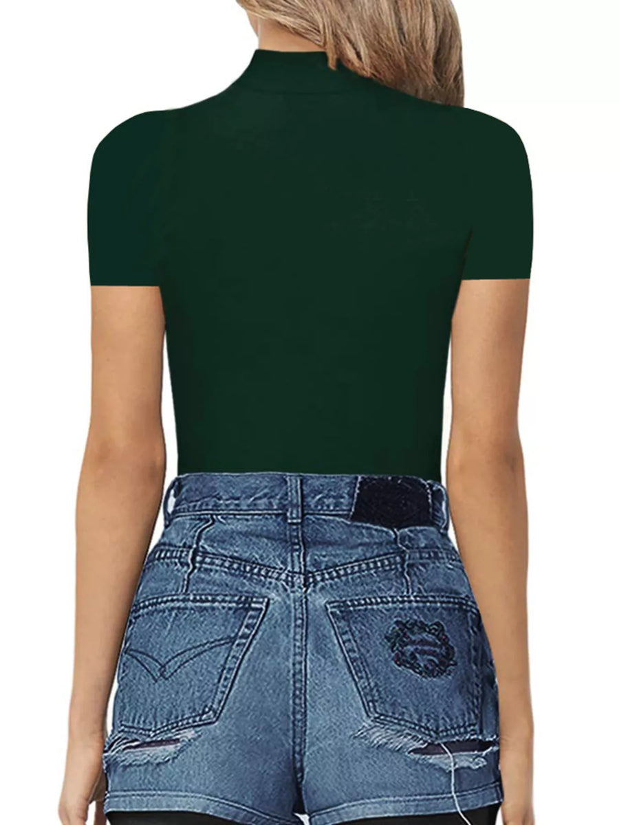 Person wearing a dark green turtleneck and blue jeans on a white background