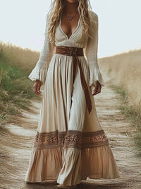 Woman wearing a long, flowing dress with a belt in a natural setting