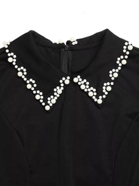 Black garment with a decorative white pearl collar on a white background