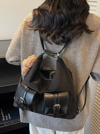 Person wearing a black backpack with a neutral background