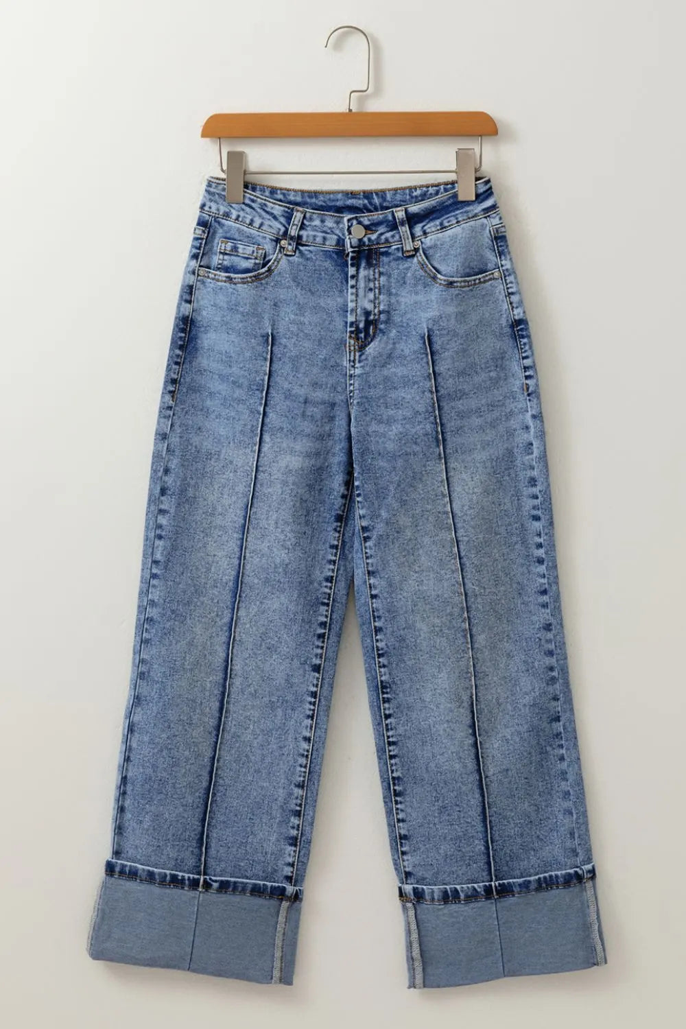 Blue jeans on a hanger against a white background