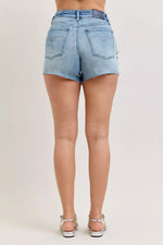 Light blue denim shorts worn by a person on a plain background