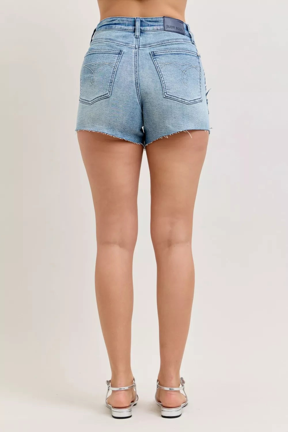 Light blue denim shorts worn by a person on a plain background