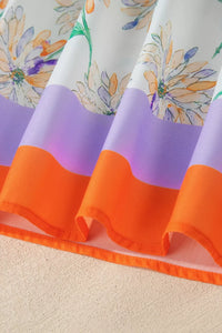 Colorful fabric with floral pattern and orange and purple sections on a beige surface