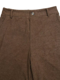 Close-up of brown corduroy pants with a button on a white background